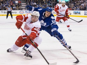 Detroit's Tomas Jurco, left, is checked by Toronto's Jerred Smithson Saturday, Dec. 21, 2013. Detroit won the Winter Classic tuneup 5-4 on Pavel Datsyuk's shootout goal. (THE CANADIAN PRESS/Chris Young)