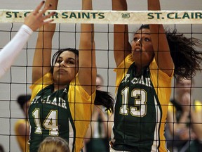 St. Clair's Kaleigh MacKenzie, left, and Samantha Bueckert try for a block against Fanshawe College in volleyball action at St. Clair College. (NICK BRANCACCIO/The Windsor Star)