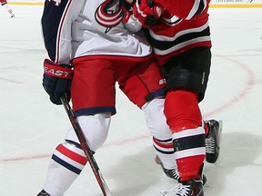 Former Spitfire Andrei Loktionov, right, is checked by Derek MacKenzie of the Columbus Blue Jackets at the Prudential Center. (Photo by Bruce Bennett/Getty Images)