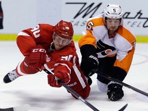 Detroit's Stephen Weiss, left, is checked by Flyers defenceman Braydon Coburn in Detroit. (AP Photo/Carlos Osorio)