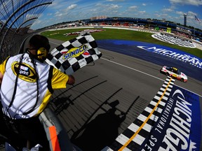 Greg Biffle, driver of the 3M/Give Kids a Smile Ford, crosses the finish line to win the NASCAR Sprint Cup Series Quicken Loans 400 at Michigan International Speedway. (Photo by Jared C. Tilton/NASCAR via Getty Images)