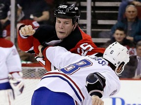 Former Spitfire Cam Janssen, back, fights Montreal's Brandon Prust Wednesday. (AP Photo/Julio Cortez)