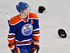 Ex-Spit Taylor Hall smiles after fans throw their hats onto the ice after Hall scored a hat trick against Colorado Thursday, December 6, 2013. (THE CANADIAN PRESS/Jason Franson)