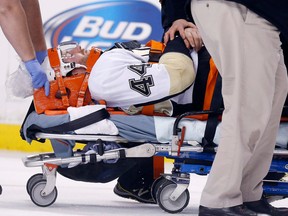 Pittsburgh's Brooks Orpik is taken off the ice after being injured in the first period against the Boston Bruins in Boston Saturday, (AP Photo/Michael Dwyer)