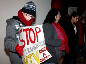 MacKenzie Davidson holds a sign during a protest demonstration at the Art Gallery of Windsor during a candlelight vigil for World AIDS Day on Sunday, Dec. 1, 2013. (JOEL BOYCE/The Windsor Star)