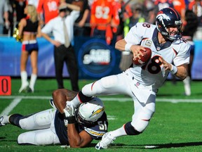 Denver quarterback Peyton Manning, right, is sacked by San Diego outside linebacker Larry English Sunday Nov. 10, 2013, in San Diego. (AP Photo/Denis Poroy)