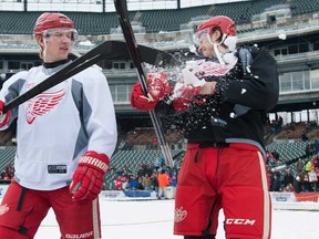 Detroit's Justin Abdelkader, left, tosses snow into the face of teammate Brendan Smith at the outdoor rink at Comerica Park Wednesday, Dec. 18, 2013, in Detroit. (AP Photo/Detroit News, David Guralnick)
