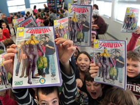 Students from Our Lady of Mount Carmel Catholic School in Windsor hold copies of The St. Clair College/ Incredible Conduit #1 comic book at the south Windsor school in Windsor, Ontario on December 10, 2013.   The comic book was launched at Our Lady of Mount Carmel Catholic Catholic School to promote literacy  and included a discussion about the importance of going to school.(JASON KRYK/The Windsor Star)