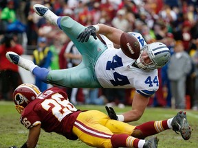 Dallas fullback Tyler Clutts, top, loses control of the ball on a hit from Washington cornerback Josh Wilson in Landover, Md., Sunday, Dec. 22, 2013. The Cowboys defeated the Redskins 24-23. (AP Photo/Alex Brandon)