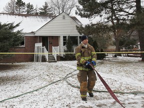 A Windsor firefighter is shown on the scene of a house fire, Friday, Dec. 13, 2013, in the 3400 block of Dougall Ave. in Windsor, Ont. (DAN JANISSE/The Windsor Star)