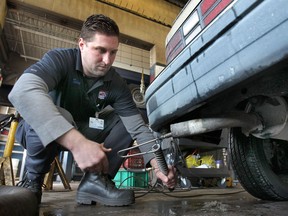 Tyler Vincent, manager at MacDonald's Automotive in Windsor, Ont. performs an emission test Wed. Dec. 18, 2013, in Windsor, Ont. The provincial government is dropping the price of the test from $35 to $30. (DAN JANISSE/The Windsor Star)