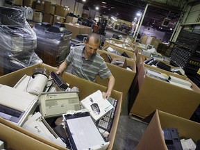 Back in April 2010, Chris Davies sorts through boxes of e-waste at Computers for Kids in Windsor. You can recycle your e-waste this Saturday at Windsor Crossing on Talbot Road from 9 a.m. to 3 p.m. (TYLER BROWNBRIDGE / Windsor Star files)
