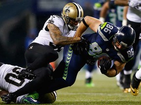 Seattle tight end Zach Miller, right, is tackled by New Orleans safety Kenny Vaccaro at CenturyLink Field on December 2, 2013 in Seattle.  (Jonathan Ferrey/Getty Images)