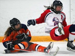 Sandwich's Hannah Sheridan, left, takes down Devon Facchinato of Holy Names in girls hockey action at South Windsor Arena Thursday Dec. 5, 2013. (NICK BRANCACCIO/The Windsor Star)