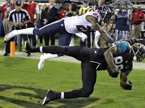 Jaguars tight end Marcedes Lewis, left, pulls in a one-yard touchdown reception in front of Houston cornerback Kareem Jackson Thursday, Dec. 5, 2013, in Jacksonville, Fla. (AP Photo/Chris O'Meara)