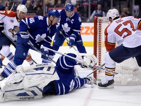 Maple Leafs goalie James Reimer, centre, scrambles to make a save as Florida Marcel Goc, right, looks for the loose puck and Maple Leaf Carl Gunnarsson defends in Toronto on Tuesday, December 17, 2013. (THE CANADIAN PRESS/Frank Gunn)