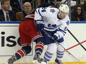 New York's John Moore, left, battles Toronto's Peter Holland at Madison Square Garden on December 23, 2013 in New York City.  (Bruce Bennett/Getty Images)