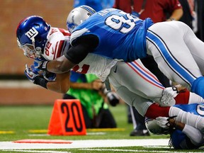 Detroit defensive end Ezekiel Ansah, top, tackles New York wide receiver Rueben Randle Sunday, Dec. 22, 2013, in Detroit. (AP Photo/Rick Osentoski)