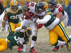 Atlanta's Steven Jackson, centre, is tackled by Green Bay's Ryan Pickett, right, and and Tramon Williams at Lambeau Field on December 8, 2013 in Green Bay. The Packers won 22-21. (Jonathan Daniel/Getty Images)