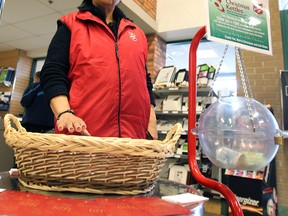 Rhoda Taylor mans the Salvation Army kettle at the Zhers store at Tecumseh and Lauzon in Windsor, Ont. on Wed. Dec. 11, 2013. After receiving complaints about the use of the traditional bells, she was forced to participate in the Christmas season fundraiser without them. (DAN JANISSE/The Windsor Star)