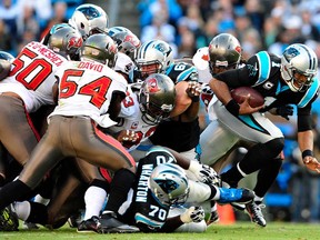 Carolina QB Cam Newton, right, breaks through the Tampa Bay defense for a first down at Bank of America Stadium on December 1, 2013 in Charlotte, North Carolina. The Panthers won 27-6. (Grant Halverson/Getty Images)