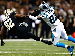 New Orleans'  Benjamin Watson, left, is tackled after catching a pass in front of Carolina's Quintin Mikell at Mercedes-Benz Superdome on December 8, 2013 in New Orleans. (Wesley Hitt/Getty Images)