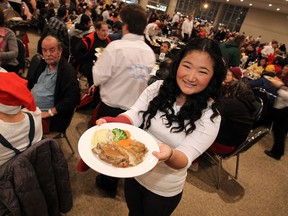 Volunteer Eileen Chen serves up hot meals during the annual Salvation Army Christmas Dinner at the St. Clair Centre for the Arts in Windsor on Wednesday, December 18, 2013.                   (TYLER BROWNBRIDGE/The Windsor Star)