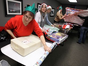 Judi Hurtubise, left, and the rest of Windsor's Secret Santa's wrap gifts for families in Windsor on Thursday, December 19, 2013. The group will provide gifts for potentially nine families this year. Families are nominated and gifts were delivered in time for Christmas.                   (TYLER BROWNBRIDGE/The Windsor Star)