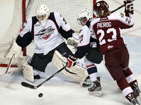 Windsor's Eric Diodati, centre, fights off the Peterborough's Stephen Pierog, right, in front of Spitfires goaltender Alex Fontinos at the WFCU Centre in Windsor on Thursday, December 12, 2013. (TYLER BROWNBRIDGE/The Windsor Star)