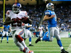 New York's Will Hill runs into the end zone for a touchdown after intercepting Lions QB Matthew Stafford, left, in Detroit, Sunday, Dec. 22, 2013. (AP Photo/Paul Sancya)