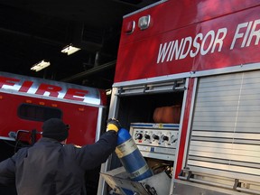 A Windsor firefighter works on a fire truck at Station 2 on Dec. 10, 2013. (Nick Brancaccio / The Windsor Star)