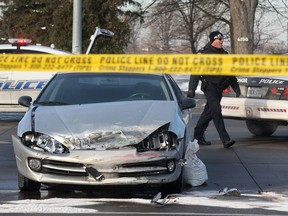 A Windsor police officer is shown at the scene of a fatal collision at the intersection of Tecumseh Rd. and Rose-Ville Garden Dr. on Mon. Dec. 16, 2013. in Windsor, ON. A pedestrian was struck and killed. A truck and a car were involved in the accident. (DAN JANISSE/The Windsor Star)