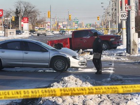 A Windsor police officer is shown at the scene of a fatal collision at the intersection of Tecumseh Rd. and Rose-Ville Garden Dr. on Mon. Dec. 16, 2013. in Windsor, ON. A pedestrian was struck and killed. A truck and a car were involved in the accident. (DAN JANISSE/The Windsor Star)