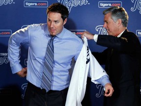 Detroit GM Dave Dombrowski, right, helps pitcher Joe Nathan put on a jersey at a news conference in Detroit Wednesday, Dec. 4, 2013. Is Dombrowski in line to become the next commissioner of major league baseball? (AP Photo/Paul Sancya)