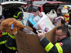 In this file photo, Chrysler Canada's Windsor Assembly Plant employees and Windsor firefighters help unload six Chrysler minivans loaded with donated toys for Sparky's Toy Drive at the Windsor Assembly Plant, Friday, Dec. 6, 2013.  (DAX MELMER/The Windsor Star)