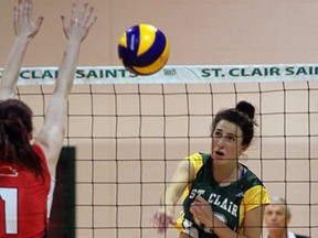 St. Clair Saints Rachel Rivers, right,  spikes against Randy Carey of Fanshawe in OCAA women's volleyball action from St. Clair College Wednesday December 4, 2013.  (NICK BRANCACCIO/The Windsor Star)