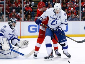 Tampa Bay goalie Ben Bishop, lefty, stops a shot as Detroit's Tomas Tatar, centre, and Lightning defenceman Matt Carle battle for position in Detroit Sunday, Dec. 15, 2013. (AP Photo/Paul Sancya)