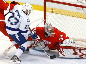 Tampa Bay's J.T. Brown, left, scores on Detroit goalie Petr Mrazek in Detroit, Sunday, Dec. 15, 2013. Tampa Bay won 3-0. (AP Photo/Paul Sancya)