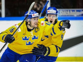Sweden's Filip Forsberg, left, and Jacob de la Rose celebrate after scoring during the World Junior Hockey Championships semifinal between Sweden and Russia at Malmo Arena in Malmo, Sweden on Jan. 4, 2014. AFP PHOTO / TT NEWS AGENCY /  LUDVIG THUNMAN