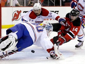 Former Spitfire Adam Henrique, right, is stopped by Montreal goalie Peter Budaj with Tomas Plekanec back on the play. (AP Photo/Julio Cortez)