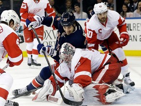 New York's Brian Boyle, centre, is stopped by Detroit goalie Jimmy Howard with Henrik Zetterberg, right, back on the play. (AP Photo/Frank Franklin II)