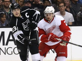 Kings captain Dustin Brown, left, is checked by Detroit's Brendan Smith at the Staples Center. (Photo by Stephen Dunn/Getty Images)