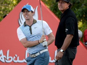 Rory McIlroy, left, and Phil Mickelson tee off on the 17th tee during the second round of the Abu Dhabi HSBC Golf Championship at the Abu Dhabi Golf Club. (Photo by Ross Kinnaird/Getty Images)