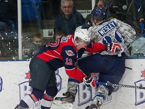 Windsor's Ben Johnson, left, is checked by Plymouth's Josh Wesley Saturday in Plymouth. (RENA LAVERTY/Plymouth Whalers)