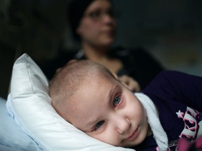 Aubri Andre, 7, who suffers from a rare form of Leukemia, is comforted by her mother, Lisa Andre, while while waiting to see a doctor about her chronic headaches, Friday, Nov. 15, 2013. (DAX MELMER/The W