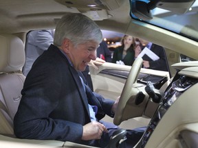 Michigan Gov. Rick Snyder checks out the interior of a Cadillac at the North American International Auto Show in Detroit on Tuesday, Jan. 14, 2014.  (DAN JANISSE/The Windsor Star)