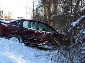 Driver of this Ford Focus was taken to hospital by Essex-Windsor paramedics after the vehicle lost control and ended up in a shallow ditch on Broadway Boulevard near Ojibway Parkway Tuesday morning, January 7, 2014. Windsor Police, shown,  arrived to investigate and Windsor firefighters also responded to the scene.  (NICK BRANCACCIO/The Windsor Star)