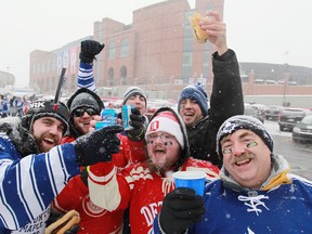 Justin Abbot, 26, left, Brett Banfill, 24, Ryan Abbott, 24, Lane Landry, 24, Ryan Allen, 26, and Jeff Abbot, 57, all from Windsor Ont., tailgate outside Michigan Stadium before the start of the 2014 Bridgestone NHL Winter Classic between the Detroit Red Wings and the Toronto Maple Leafs, Wednesday, January 1, 2014.  Toronto defeated Detroit 3-2 in a shootout.   (DAX MELMER/The Windsor Star)