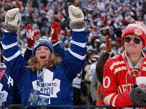 A Leafs fan cheers while a Red Wings fans shakes his head after Toronto's first goal of the  2014 Bridgestone NHL Winter Classic between the Detroit Red Wings and the Toronto Maple Leafs at Michigan Stadium in Ann Arbor, Wednesday, January 1, 2014.  Toronto defeated Detroit 3-2 in a shootout.   (DAX MELMER/The Windsor Star)