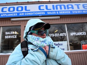 Windsor resident Denile Hooper tries to stay warm while waiting for a bus on Jan. 27, 2014. (Nick Brancaccio / The Windsor Star)